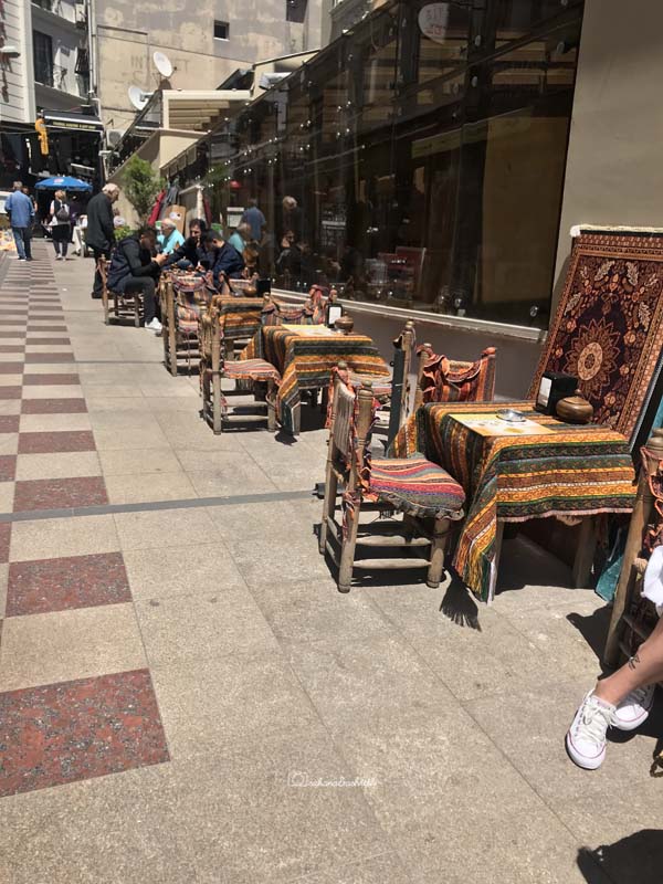 Sidewalk cafes with furnitures upholestered with goregeous bright red Turkish rugs in ISTANBUL