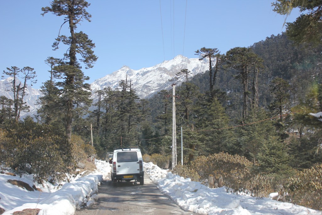 Tata Sump as Jeep taxi in Yumthan Sikkim going on asphalt road with snow on either side