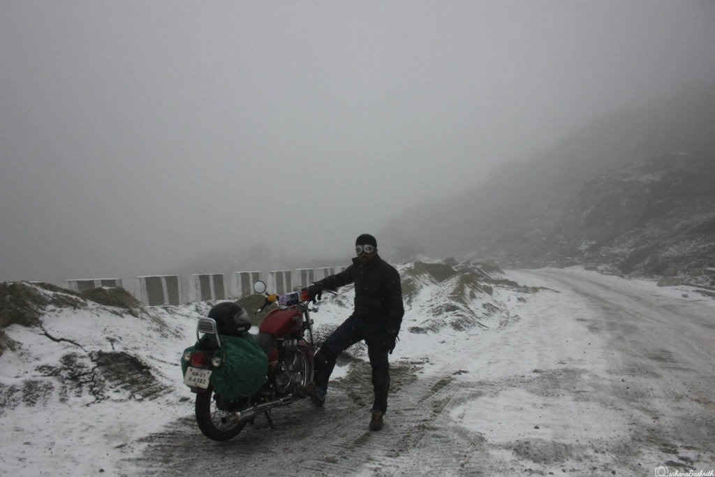Indian biker with Royal enfield bike stuck on the snow filled road of sikkim