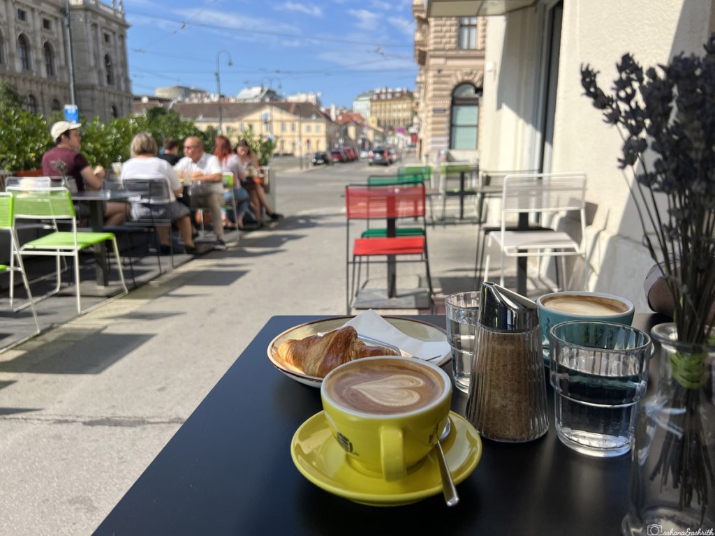 cappuccino in yellow cup by the streetside in Vienna