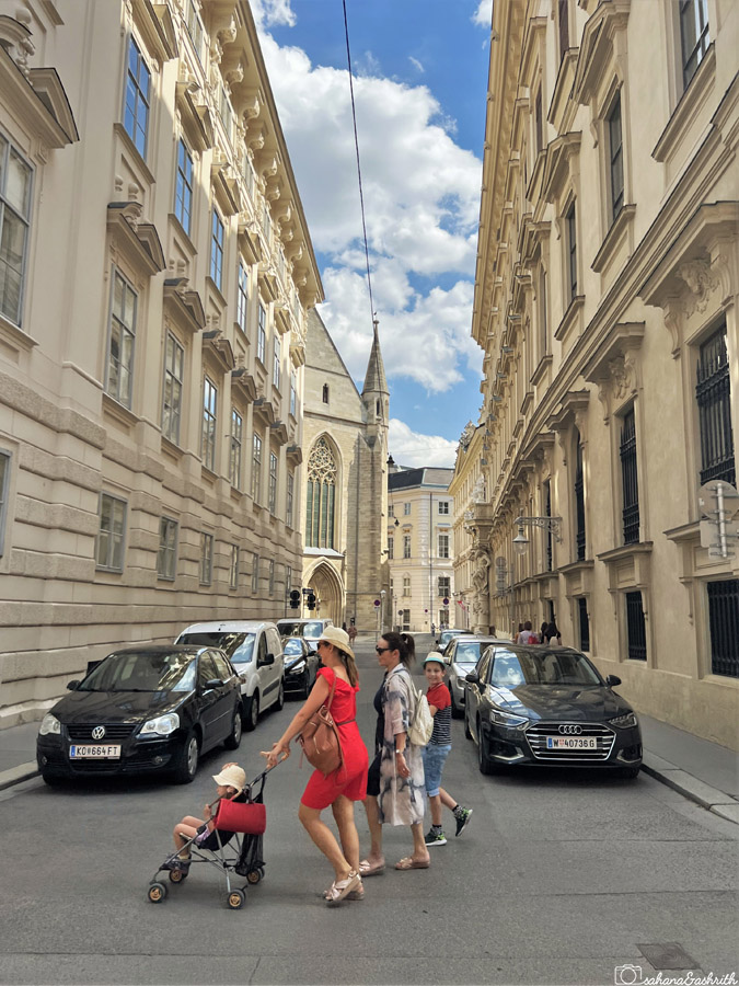 Women with baby stroller walking on the heritage streets with classical tall buildings on both side in Vienna