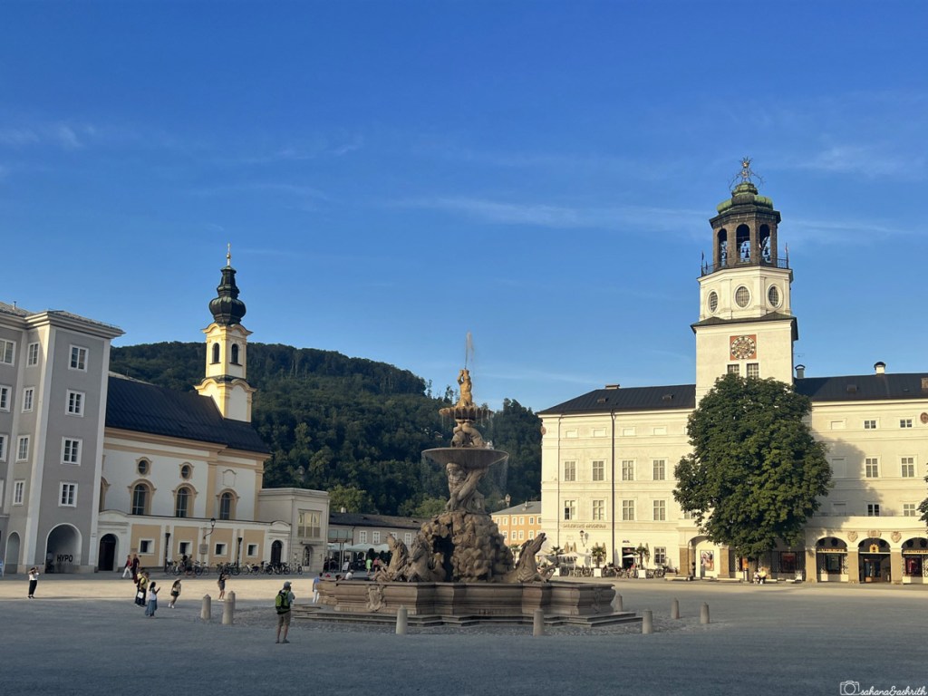 Baroque style building lining the square with a fountain in the centre at Salzburg