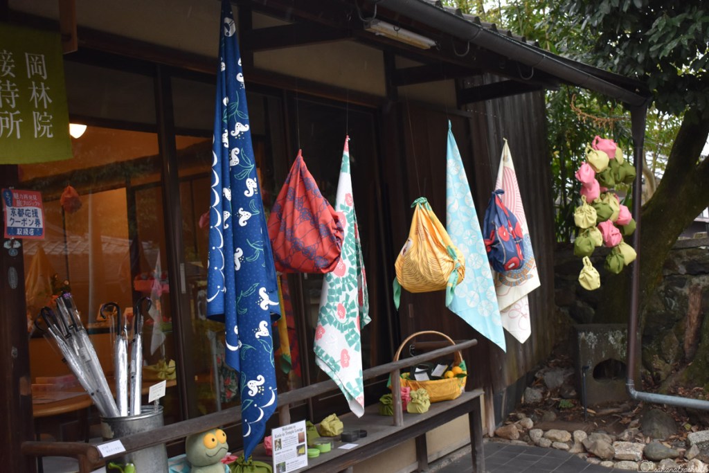 colourful fabrics hung infront of a traditional japanese wooden builing at Kyoto in Japan