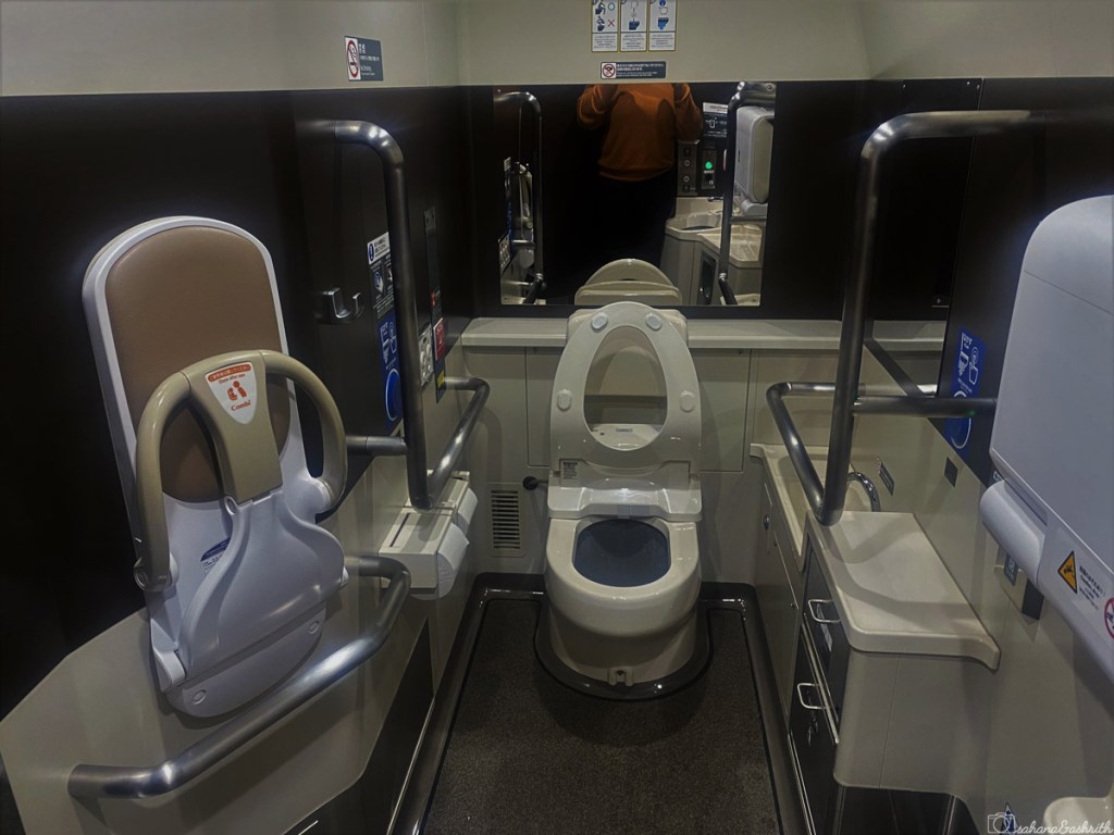Toilet inside bullet train with commode, baby station, small sink 