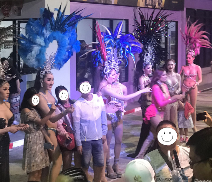 tourists clicking photos with lady boy performers in glamorous clothing at cabaret show in phuket, thailand
