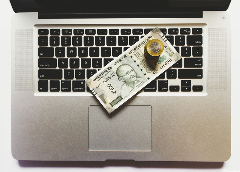 indian currency kept on a laptop