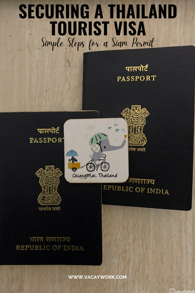 Two Indian passports placed side by side, featuring a Chiang Mai fridge sticker at the center."