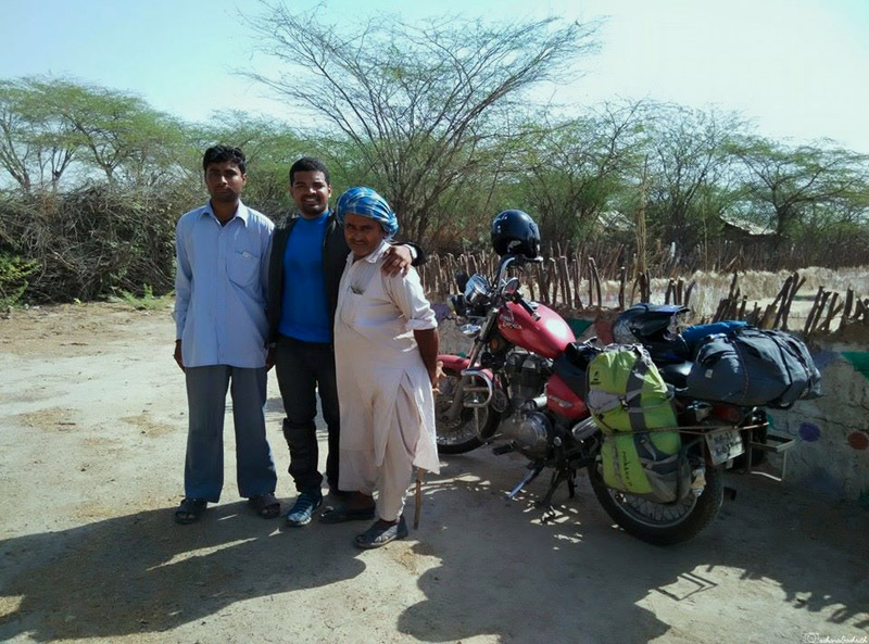 Ashrith Shetty with local homestay hosts of Kutch in their front yard surrounded by desert and dry bushes