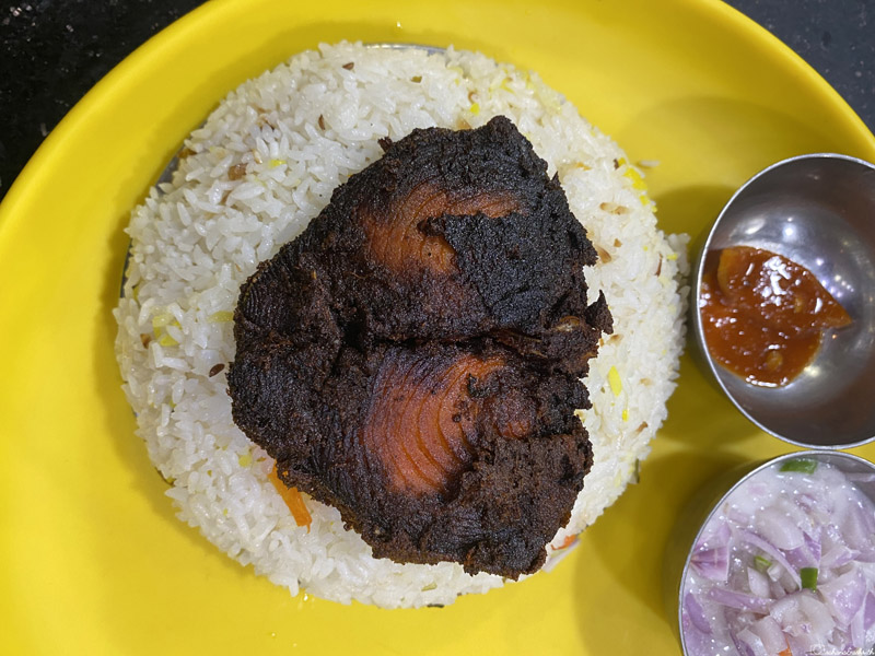 india travel guide for food: fried fish on rice in a plate with onions on sides
