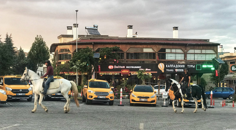 two men on horse dressed as cow boys in the middle of the street in cappadocia, Turkey