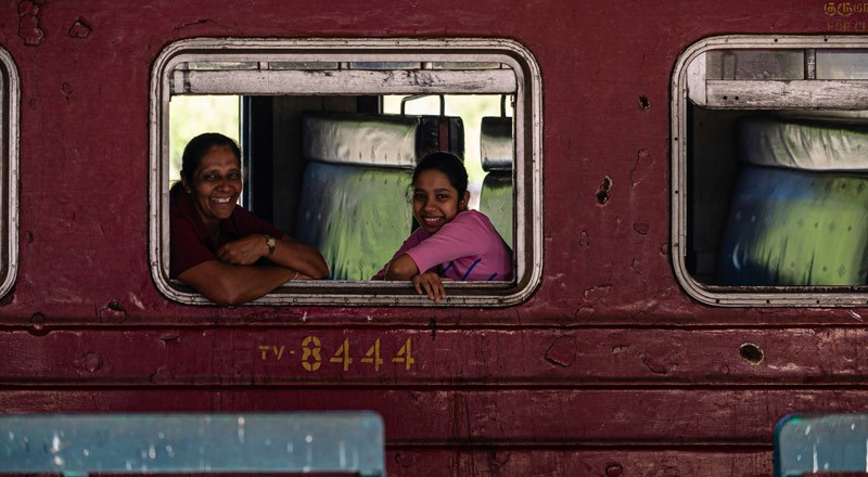 two sri lankan woman in a train smiling