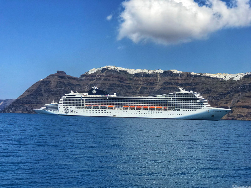 Aegean Sea cruise passing Oia's brown soil mountains in Greece