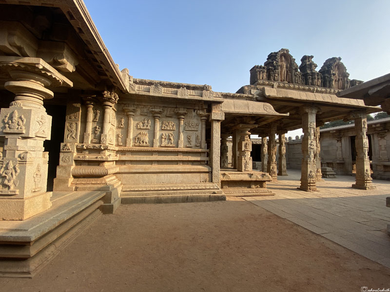 Inside courtyard of Hazara Rama Temple with temple wall adorned with relief sculptures depicting Ramayana stories.