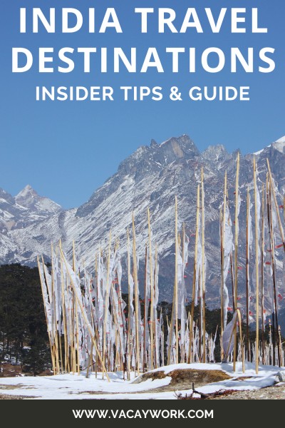 pinnable image for india travel tips for first timers featuring tall buddhist white flags with chants written on it in the middle of snow field surrounded by himalayas