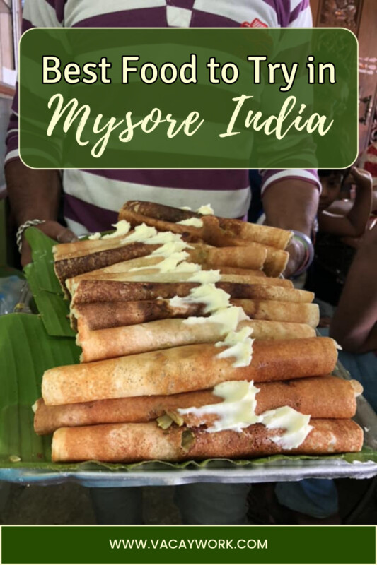 Man holding a tray full of crispy dosas topped with butter with text on it that says Best Food to Try in Mysore India