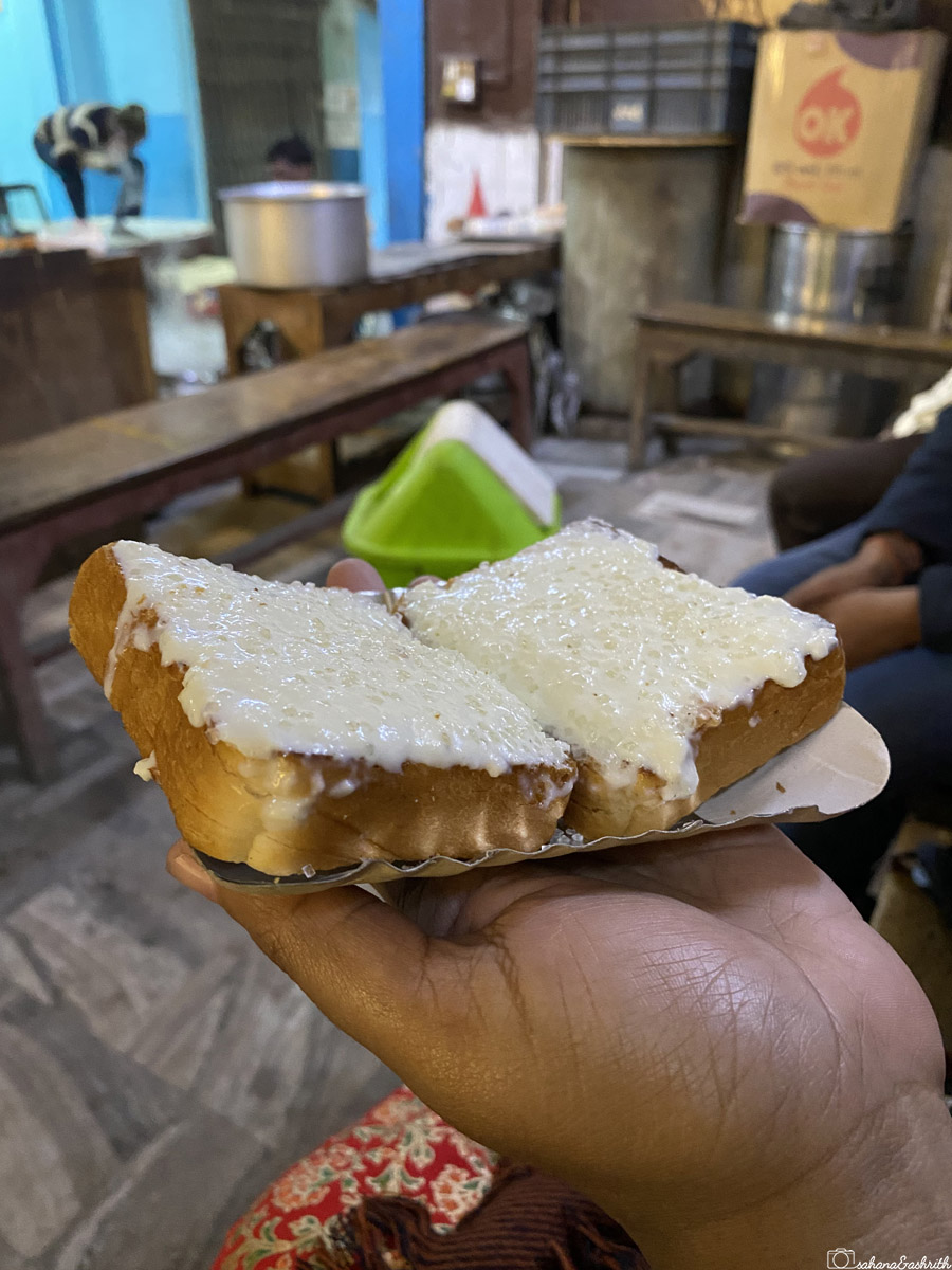 A slice of bread topped with thick cream (Malai) at Lakshmi chai wala