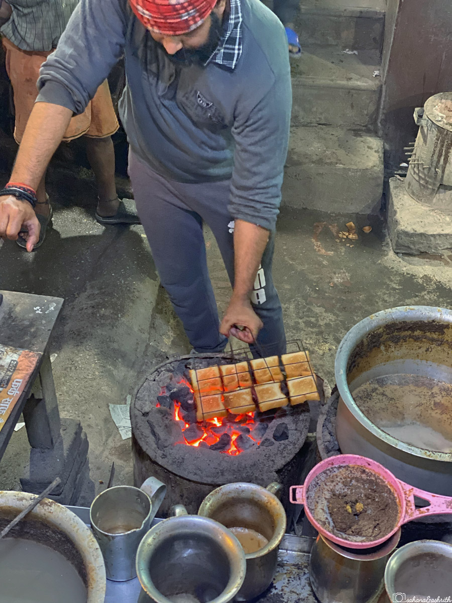 A vendor grilling bread on charcoal at Lakshmi chai waala
