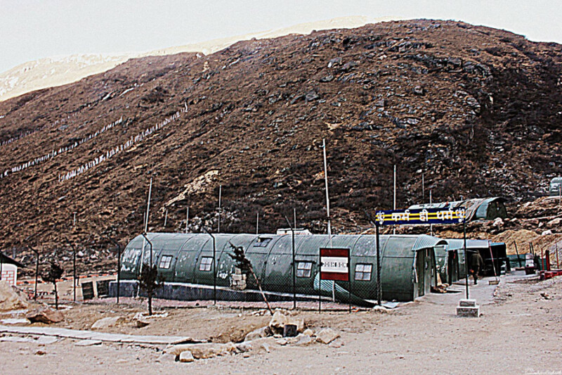 A military camp where Ashrith and his friends were rescued with green tents nestled in a rugged, mountainous terrain