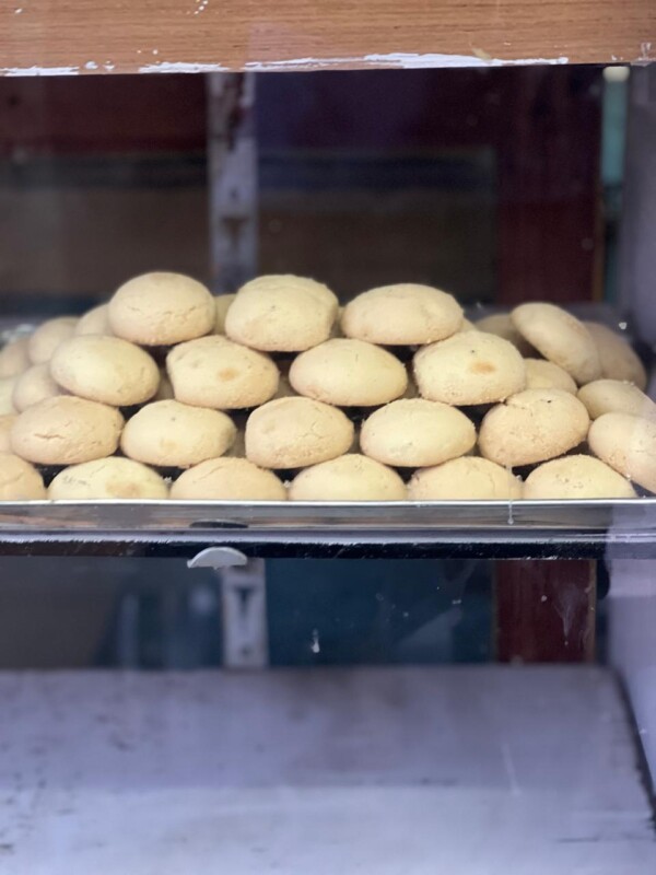 A tray of freshly baked nankhatai biscuits neatly arranged in a display case at Tea Corner, Mysore