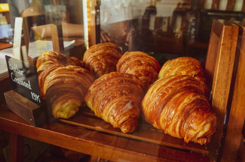 Butter croissants in a glass display case 