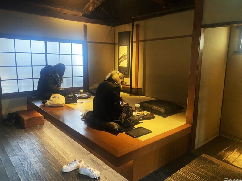 Two people sitting in a traditional Japanese tatami room enjoying their meal, showcasing Japanese dining culture.