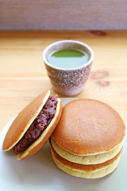 Delectable Dorayaki Cakes with a Cup of Hot Matcha Green Tea in the Backdrop