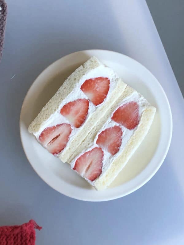 japanese strawberry sandwich cut into 2 halves showing strawberry surrounded by cream between bread cream