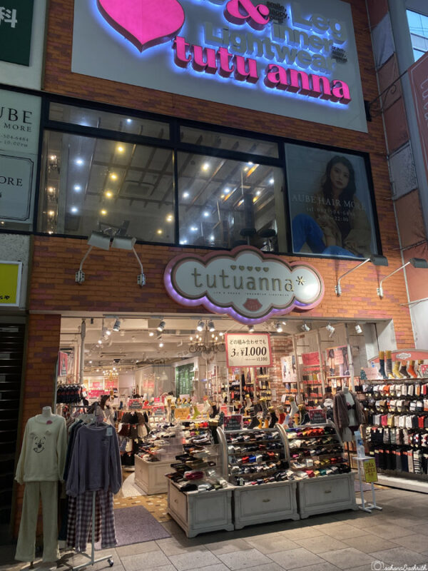Bright storefront of Tutu Anna shop in hondori shopping arcade selling legwear and innerwear, showcasing a variety of socks and accessories with signage