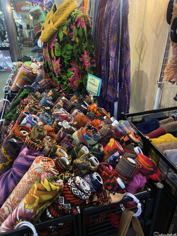 Colourful display of fabric rolls and scarves with vibrant patterns and textures at Hiroshima’s local market, showcasing Japanese style at Hondori