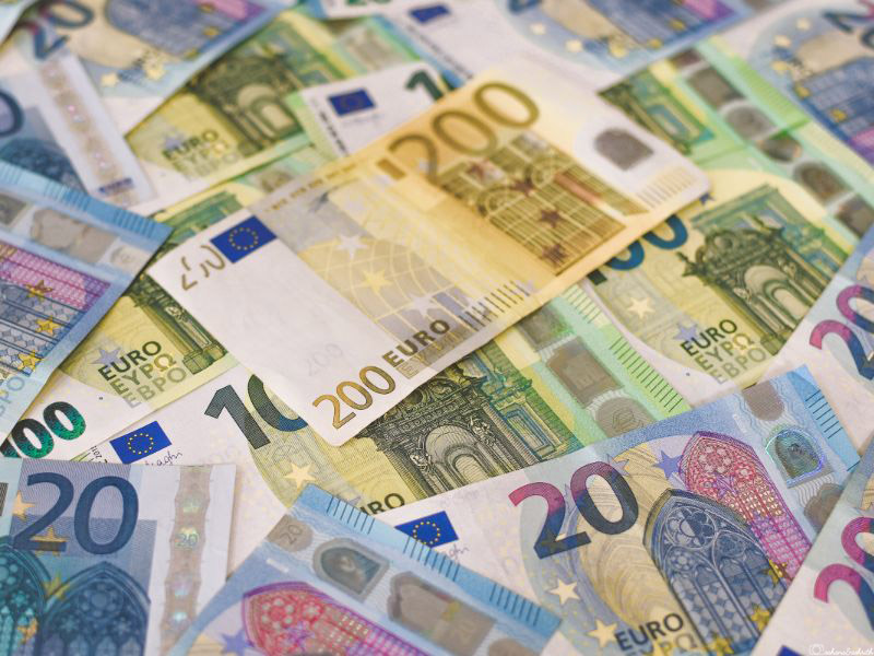 greece travel guide showing various denominations of euro currency spread on table