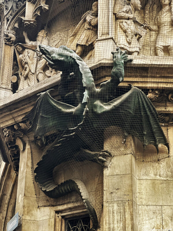A stone sculpture of a dragon crawling on Munich Residenz Palace.