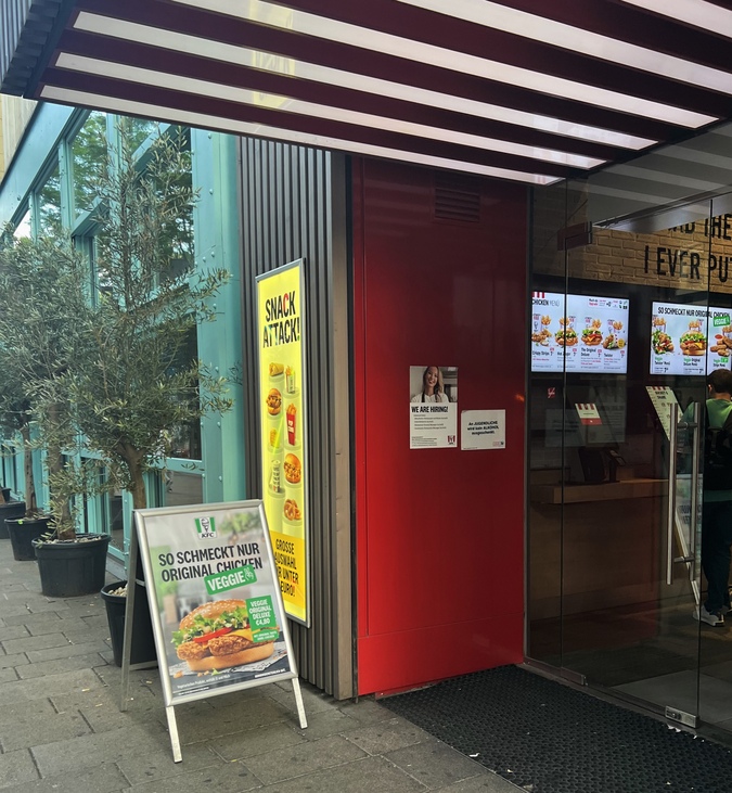 KFC burger joint in Vienna with a display ad for a veggie burger outside at the entrance.