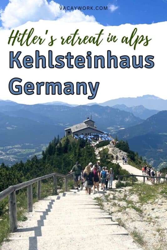People walking up a gravel path towards the Eagle’s Nest building on a ridge, with views of Berchtesgaden valley and the Bavarian Alps, with text overlay that says Hitler’s retreat in Alps Kehlsteinhaus Germany