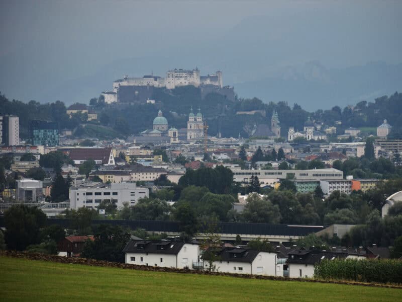 Salzburg city skyline with fortress, domes, and spires seen from hilltop near Maria Plain trail
