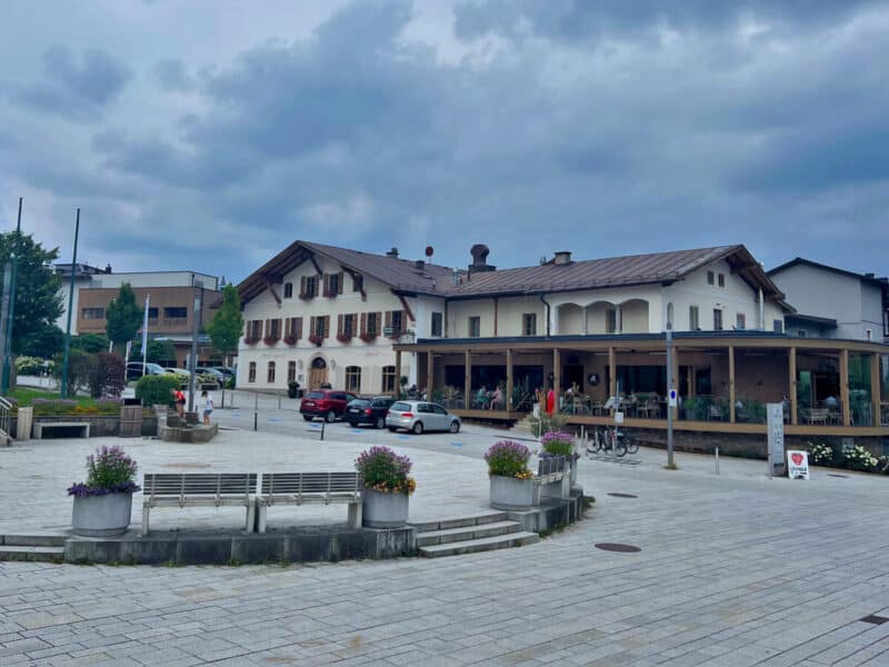pen plaza in Bergheim with parked cars and Gasthof Gmachl building lined with windows and shutters
