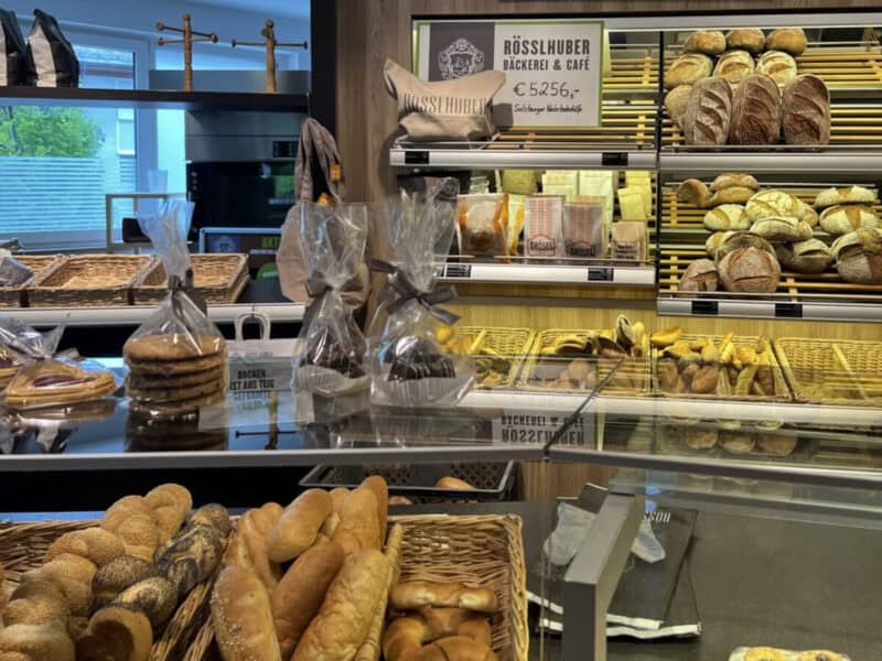nterior of Rösslhuber bakery café with neatly arranged breads, rolls, and packed cookies