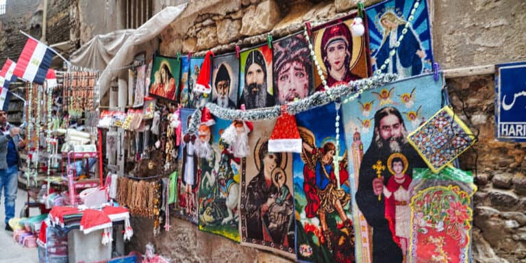 Street market in Cairo selling colourful Coptic Christian art and souvenirs featuring saints