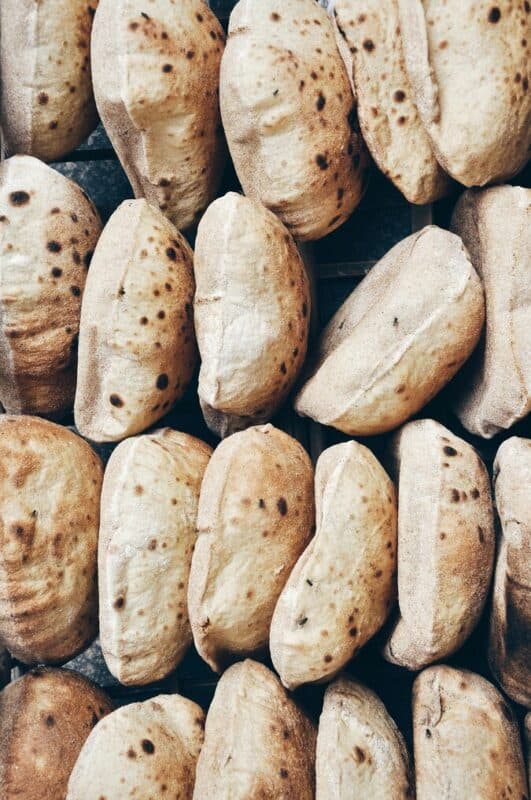 Stacks of freshly baked Egyptian baladi bread at a local bakery.