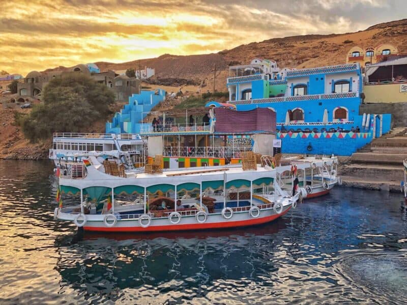 Colourful boats docked by Nubian houses along the Nile in Aswan, Egypt.