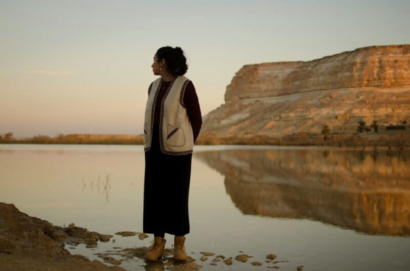 Woman standing by the lake at sunset in the Fayoum desert, Egypt.