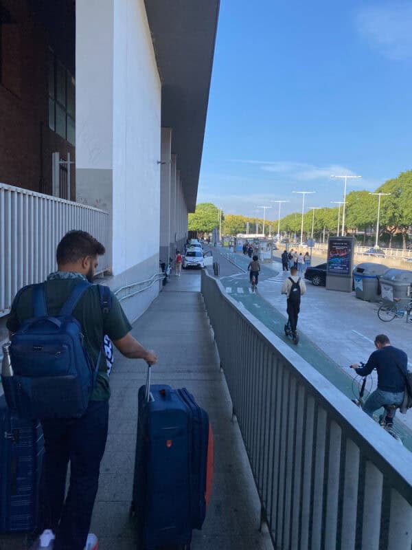 ashrith pulling trolley suitcase down the ramp outside seville bus stand