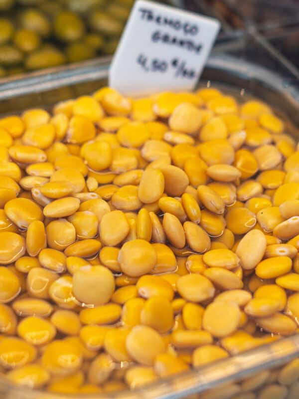Tray of yellow lupini beans soaking in brine at a Portuguese market stall
