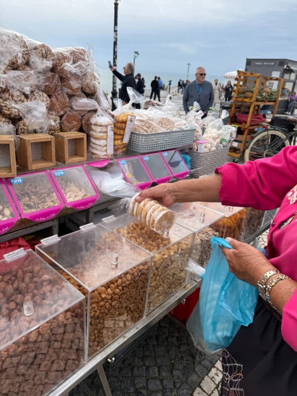 Nazare Street stall selling candied nuts and traditional sweets along a seaside promenade in Portugal.