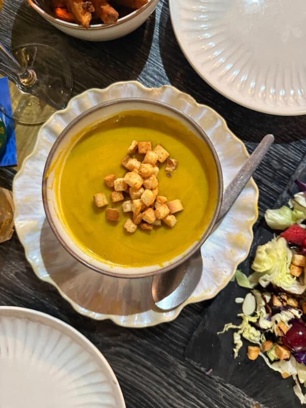 Bowl of smooth vegetable soup topped with croutons, a classic caldo verde style starter in Portugal.