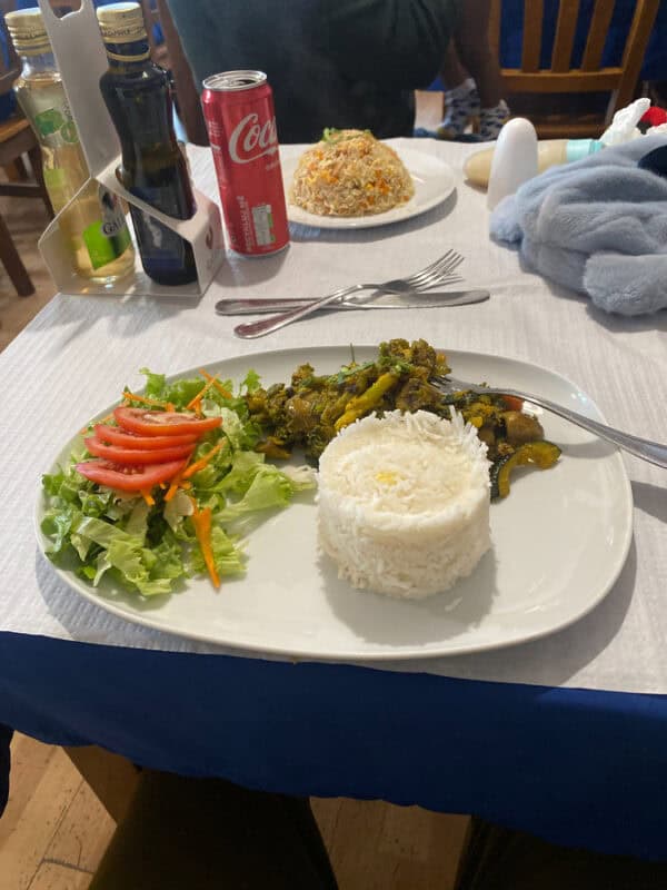 Plate with rice, sautéed vegetables and side salad served at a family restaurant in Portugal.