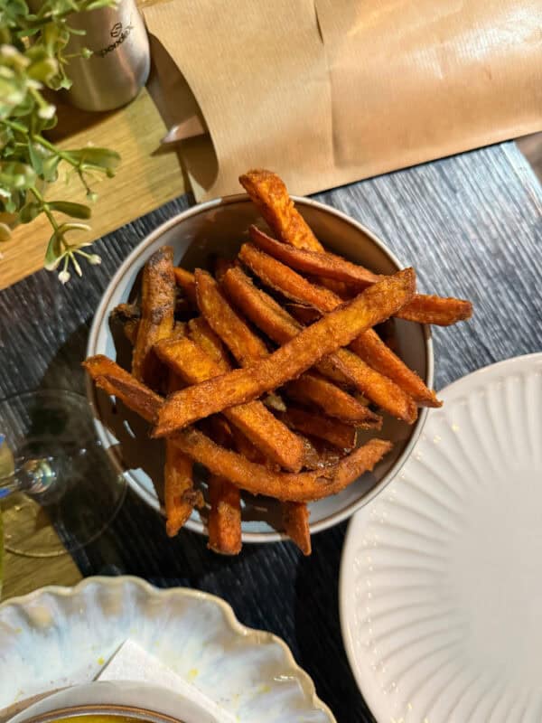 Bowl of crispy sweet potato fries served as a side dish at a casual restaurant in Portugal.