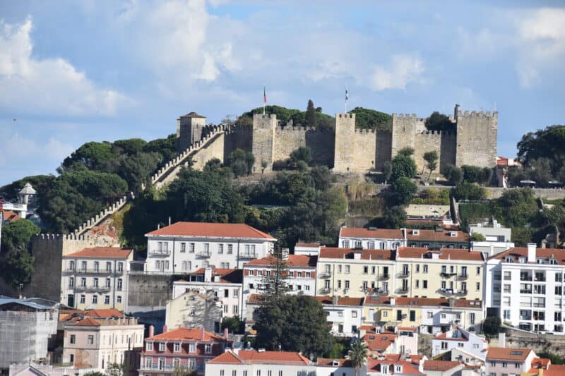 São Jorge Castle rising above Lisbon houses and trees on a sunny day
