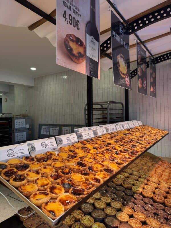Display of freshly baked pastéis de nata and Portuguese pastries inside a Lisbon bakery.