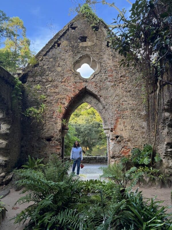Historic stone archway surrounded by lush greenery in Sintra, Portugal.