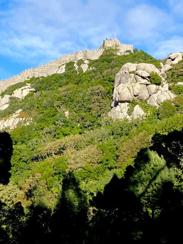 Historic castle atop lush green hill in Sintra Portugal.
